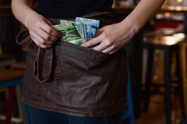 Waitress server using apron pocket to store keep cash money tips